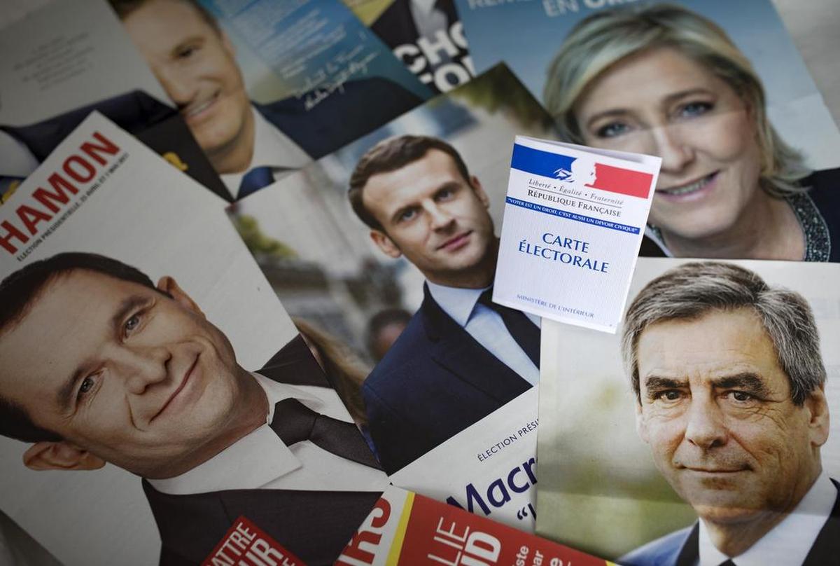 Una credencial para votar es fotografiada sobre los panfletos de los once candidatos para las presidenciales francesas en París, el viernes 21 de abril de 2017. Francia celebra elecciones el próximo domingo.