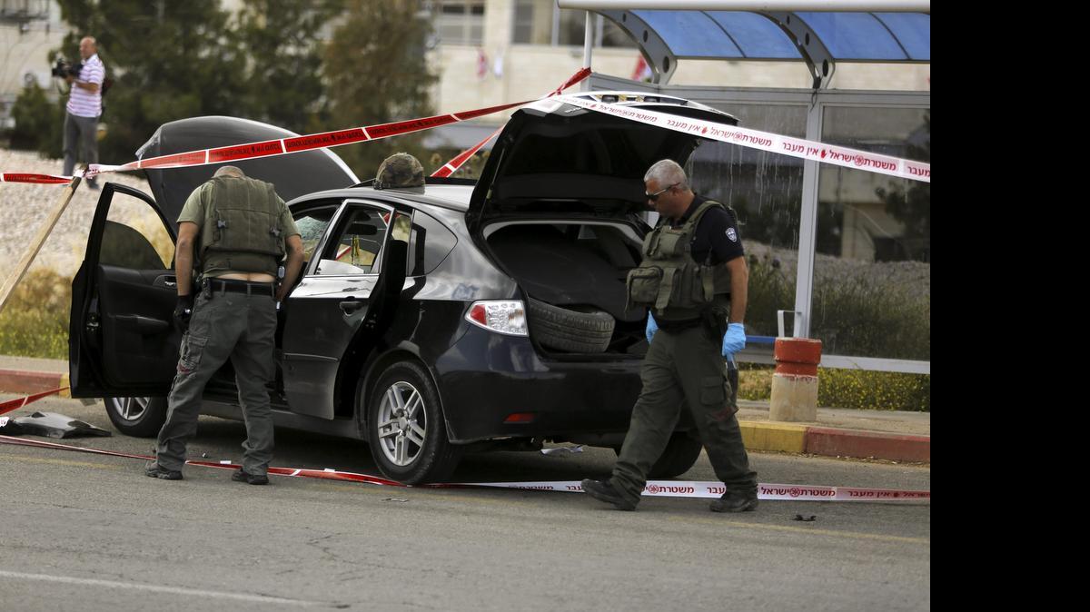 
Varios policías israelíes inspeccionan el coche que supuestamente pertenece al palestino Mohammed al-Rifai, sospechoso de perpetrar un posible atropello a la entrada de un asentamiento israelí, en Cisjordania,el jueves. 
