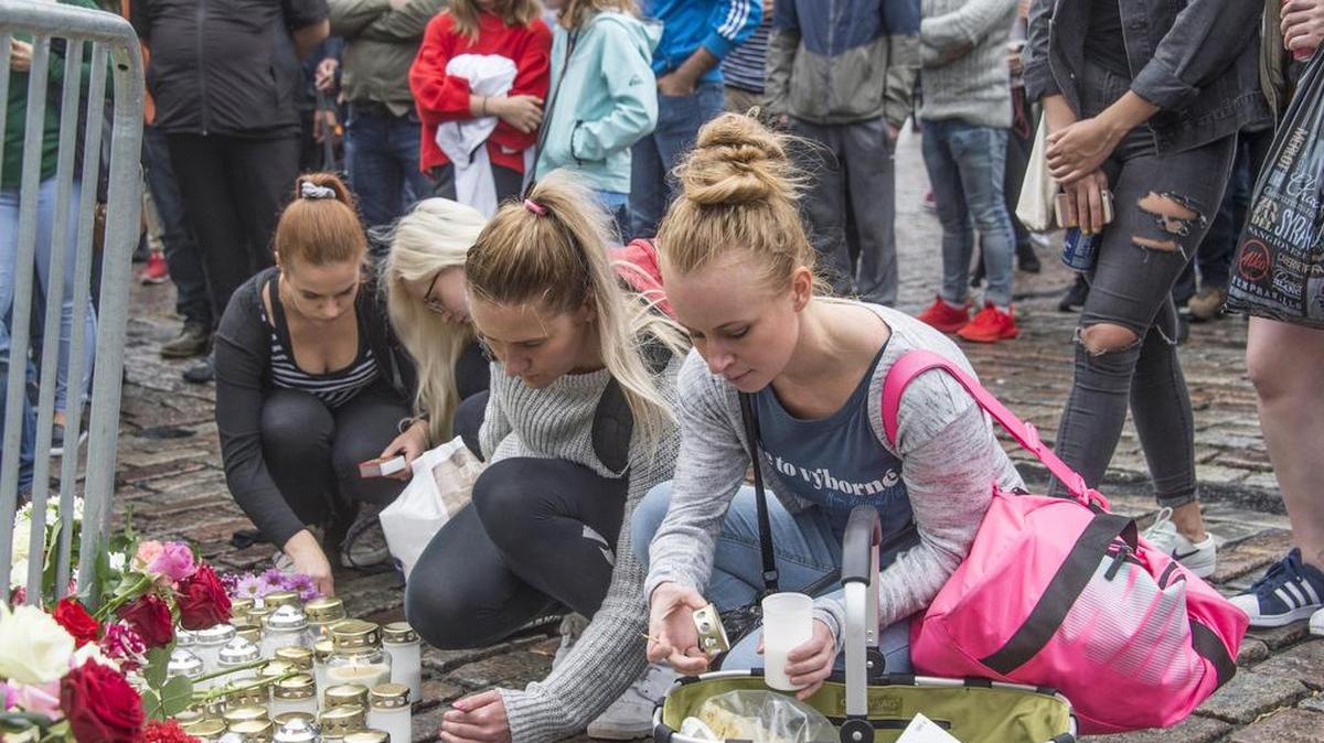 Personas colocan velas y flores en el mercado en Turku, Finlandia, 19 de agosto de 2017 después del ataque fatal la tarde siguiente.