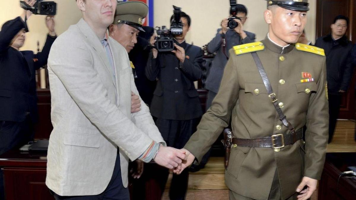 Fotografía de archivo de la agencia estatal de noticias norcoreana (KCNA) que muestra al estudiante estadounidense Otto Frederick Warmbier (i), esposado durante su juicio en la Corte Suprema de Corea del Norte el 16 de marzo de 2016. Warmbier, que estuvo preso en Corea del Norte durante más de un año y fue entregado la semana pasada en coma a su familia, falleció el 19 de junio en su Ohio natal, informó su familia.