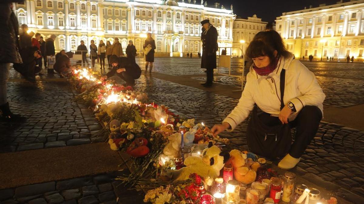 Una mujer enciende una vela en memoria de las víctimas del accidente de avión en la plaza Dvortsovaya en San Petersburgo, Rusia, el martes, 3 de noviembre de 2015.