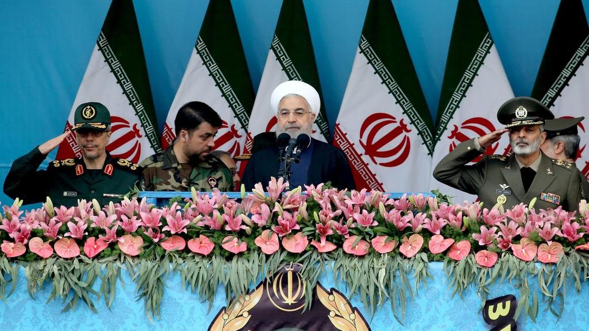 El presidente iraní, Hassan Rouhani (C) asiste a un desfile militar rodeado de oficiales durante una ceremonia que conmemora el día anual del ejército en Teherán, el 18 de abril de 2019. -