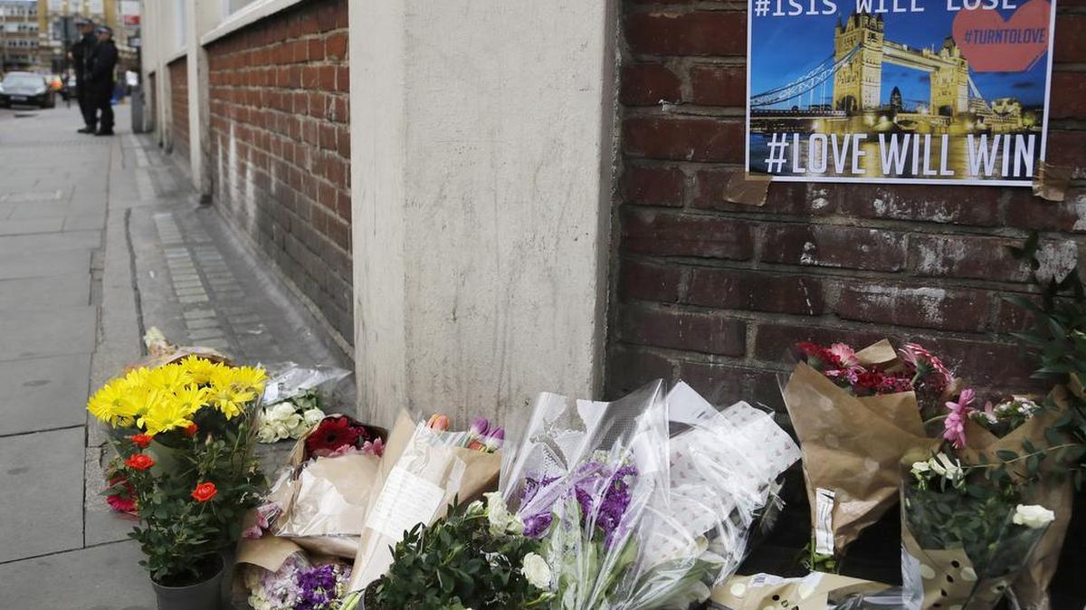 La policía guarda una esquina cerca de un tributo de flores y carteles en el área de London Bridge, Londres, el domingo 4 de junio de 2017.