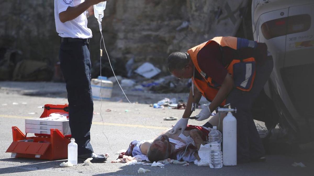 
Miembros de los servicios de emergencia atienden a uno de los soldados atropellados por un vehículo conducido por un palestino en la ruta 60 junto a la aldea cisjordana de Sinyil, el jueves. 
