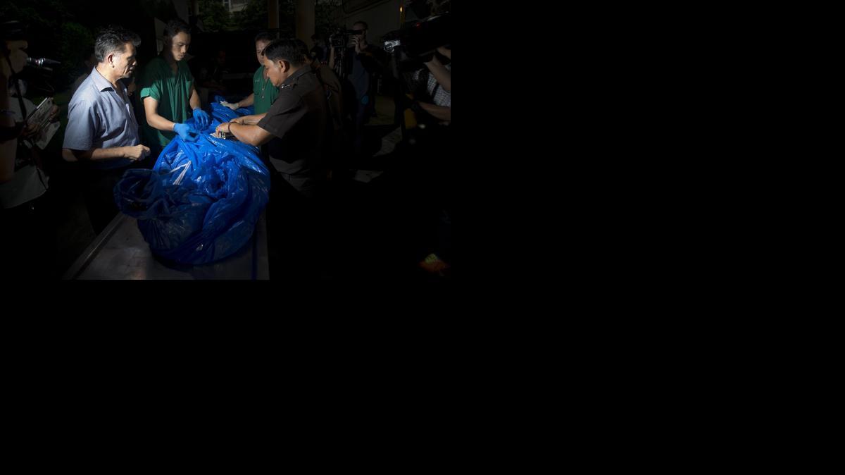
El cuerpo envuelto en plástico de la turista asesinada, Hannah Witheridge cuando era trasladado a las oficinas de la policía forense en Bangkok, Tailandia. Dos detenidos confesaron el jueves, haber sido los autores del crimen.





