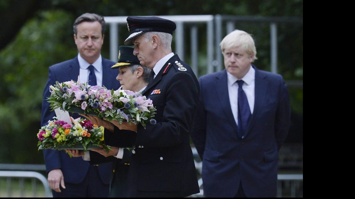 
El primer ministro británico, David Cameron (izq.), y el alcalde de Londres, Boris Johnson (der.), participan en una ceremonia conmemorativa ante el monumento a las víctimas, en Londres, Reino Unido,e; martes.
