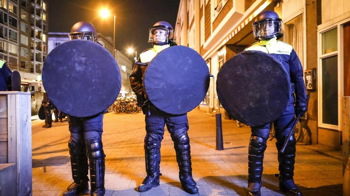 Miembros de la policía acordonan una calle mientras cientos de manifestantes ondeando banderas turcas se reúnen fuera del consulado turco en Rotterdam, Holanda, el 11 de marzo de 2017.