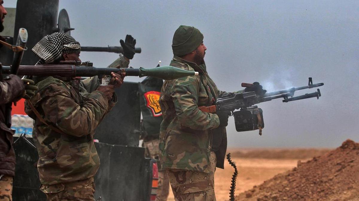 Combatientes chiítas iraquíes disparan contra el grupo del Estado islámico mientras avanzan cerca del pueblo de Tal Abtah, al sur de Tal Afar, el 30 de noviembre de 2016.
