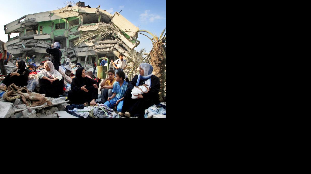 
Una familia palestina frente al destruído edificio de apartametos donde vivía en la Franja de Gaza.
