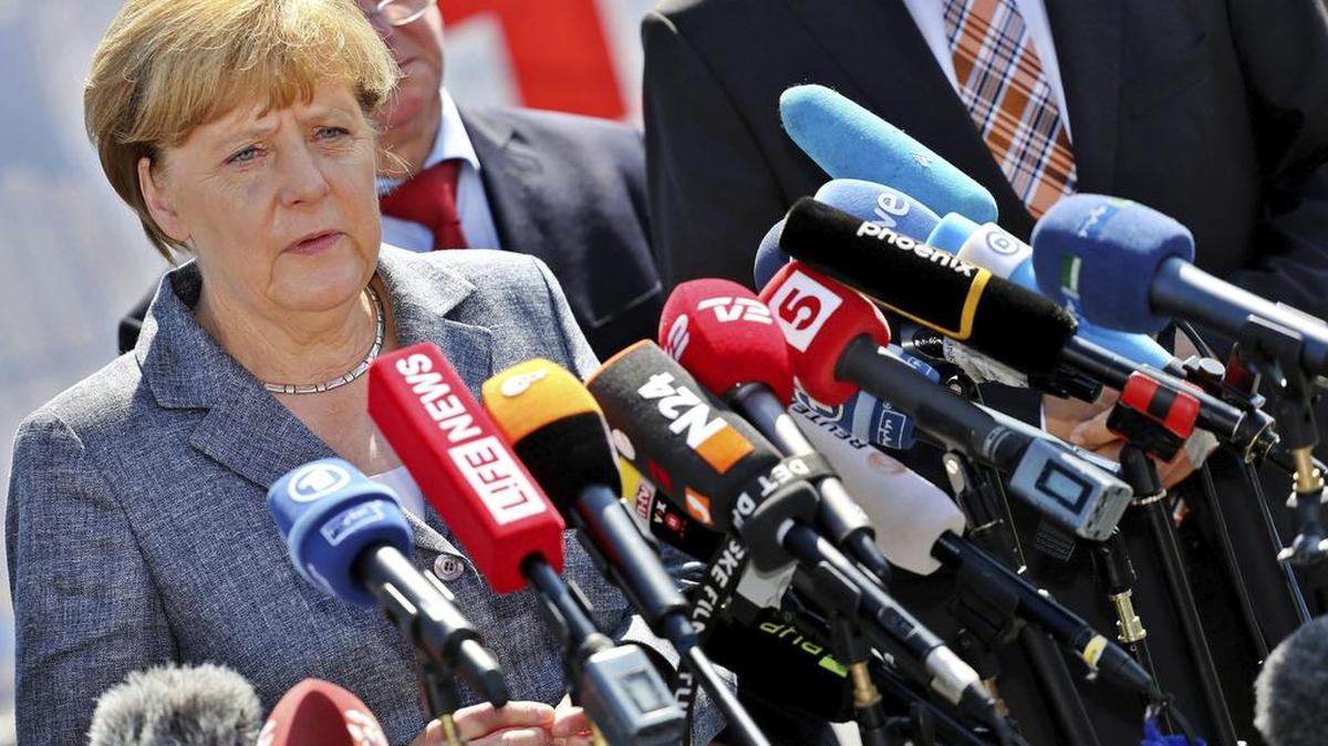 
La canciller Angela Merkel se dirige a los medios tras su visita, el miércoles, al centro de refugiados objeto de violencia por parte de grupos neonazis en Alemania.
