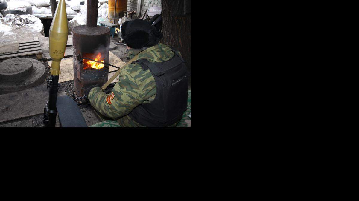 <cutline_leadin>Un separatista</cutline_leadin> prorruso se calienta junto a una estufa en un puesto de control en la ciudad de Donetsk con una temperatura de -15C, este sábado.