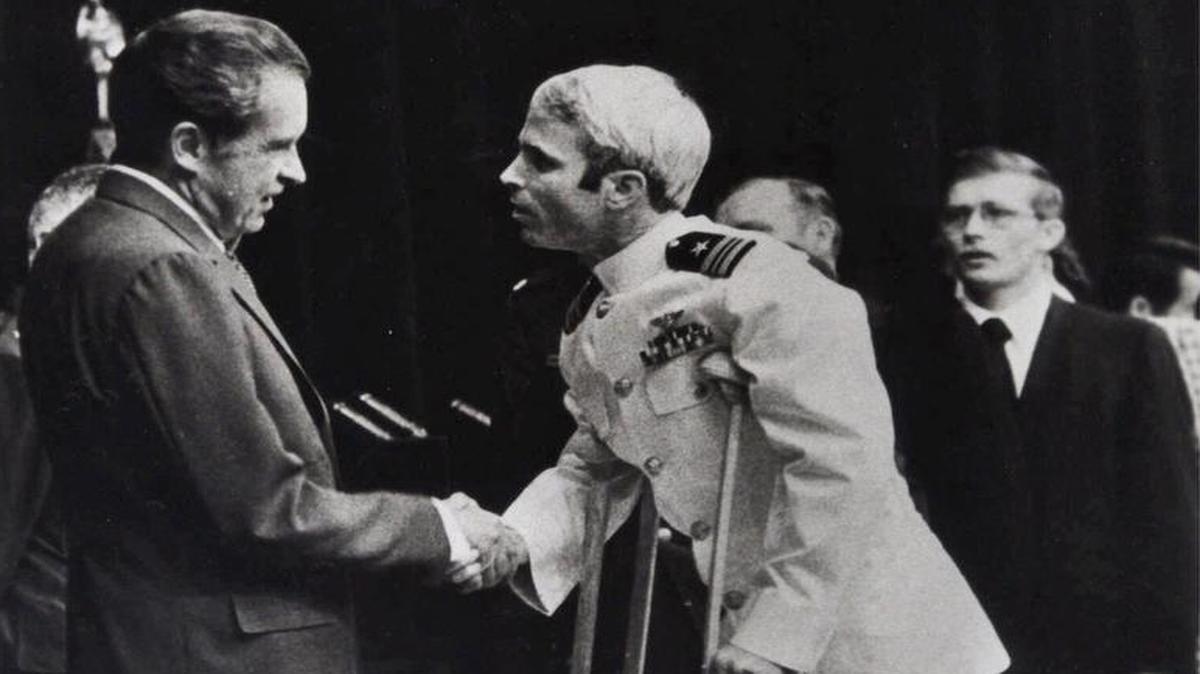 
John McCain en muletas estrecha la mano al entonces presidente de EEUU Richard Nixon en Washington. 
