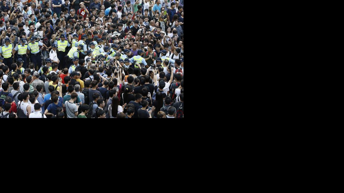 
Policías se abren paso por entre la multitud para arrestar a un líder de las manifestaciones que el gobierno local ha prohibido, en Hong Kong, China. 
