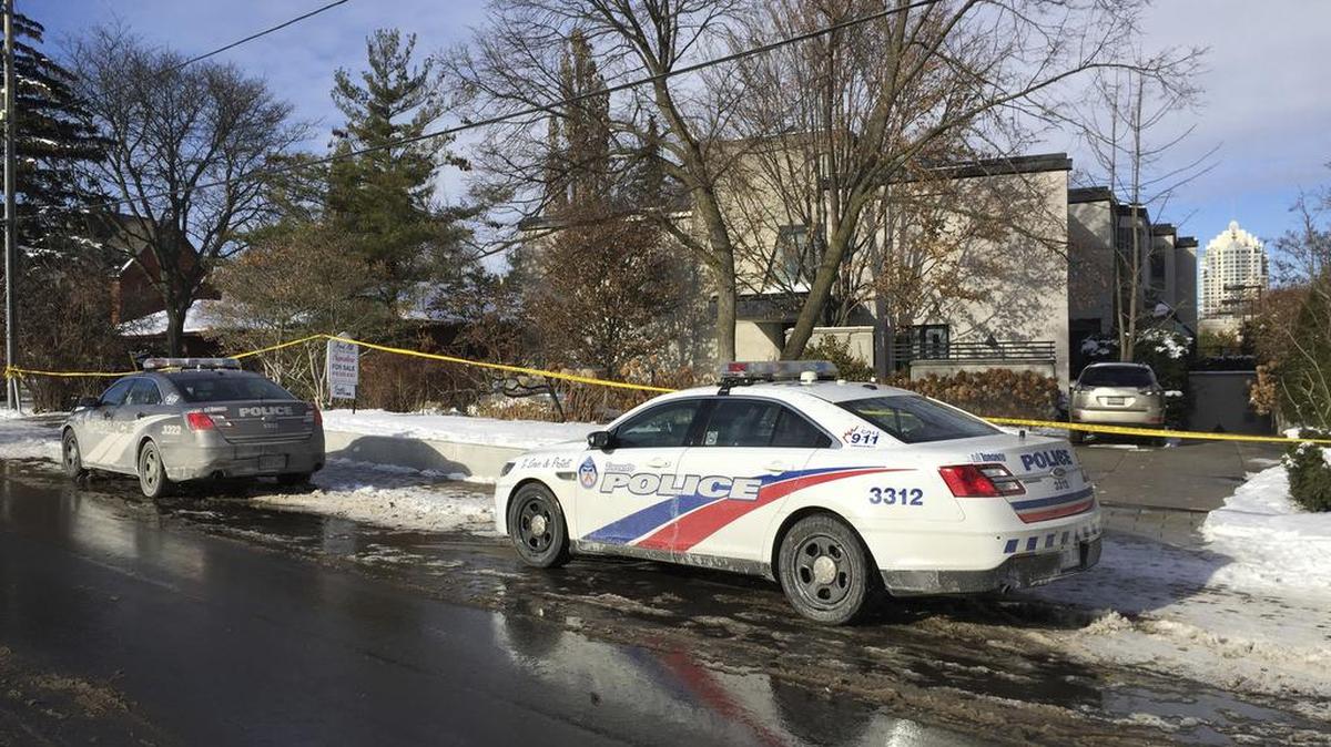 Patrullas policiales están estacionados afuera de la casa del multimillonario Barry Sherman el sábado 17 de diciembre de 2017 en Toronto.