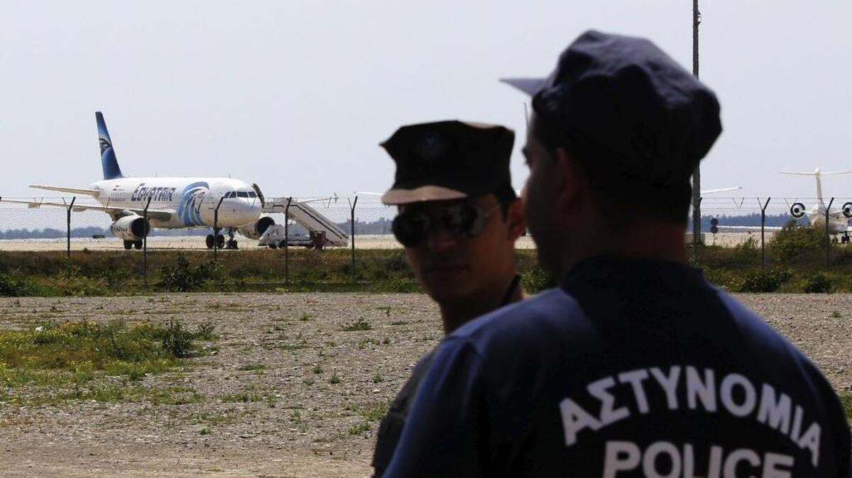 Policías montan guardia cerca del avión de Egiptair secuestradoo por un pasajero con un cinturón explosico en el aeropuerto de Larnaca (Chipre) hoy, 29 de marzo de 2016.