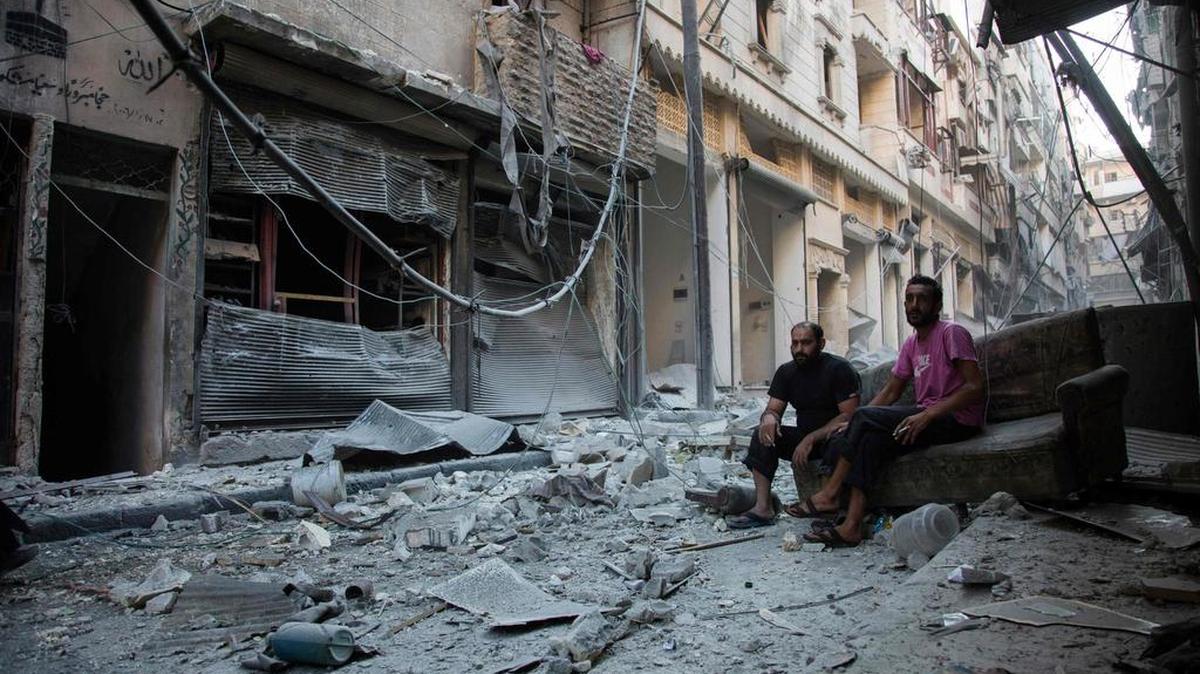 Residentes observan los escombros después de un ataque aéreo de los EEUU en la ciudad de Karm al-Jabal, controlada por el régimen sirio, el 18 de septiembre del 2016.