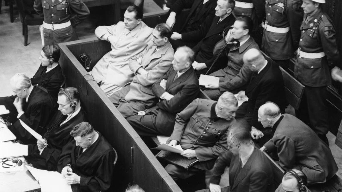 Mariscal de Campo Wilhelm Keitel (En la segunda fila, el cuarto desde la izq.) se dirige al general Alfred Jodl, en los juicios en Palacio de Justicia de Nuremberg, en noviembre de 1945. De izq. a der. los acusados Hermann Goering, Rudolf Hess, Joachim von Ribbentrop, Keitel, Alfred Rosenberg, Hans Frank y Wilhelm Frick. En la fila trasera, de izq. a der.: Karl Doenitz, Erich Raeder, Baldur von Schirach y Fritz Sauckel.