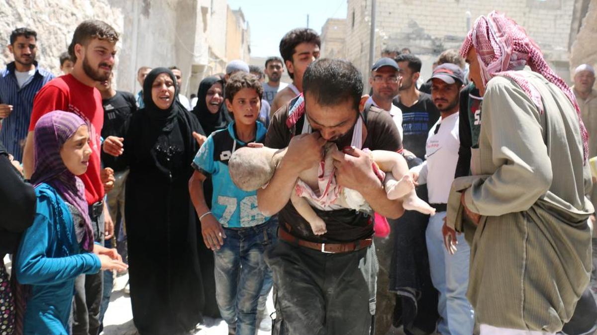 Un hombre carga a su hijo tras sacarlo de los escombros de un edificio destruido por un bombardeo aéreo en Alepo, Siria, el 24 de julio del 2016.