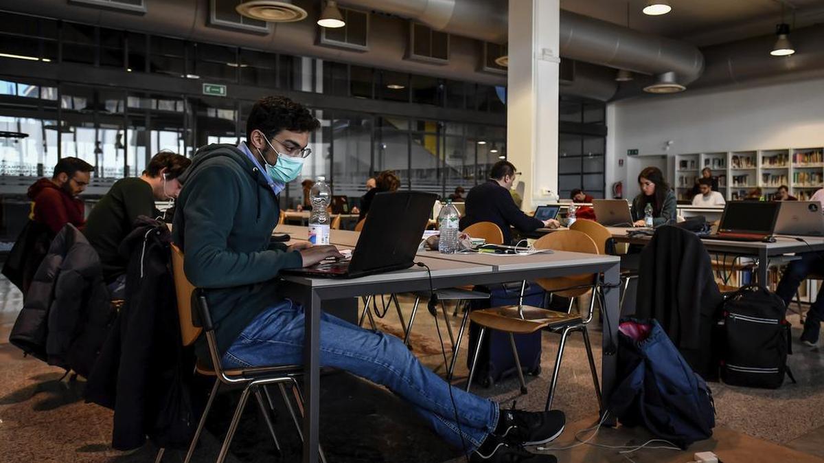 Un estudiante con una mascarilla revisa su computadora en la biblioteca el miércoles en la Universidad Politécnica de Milan, Italia.