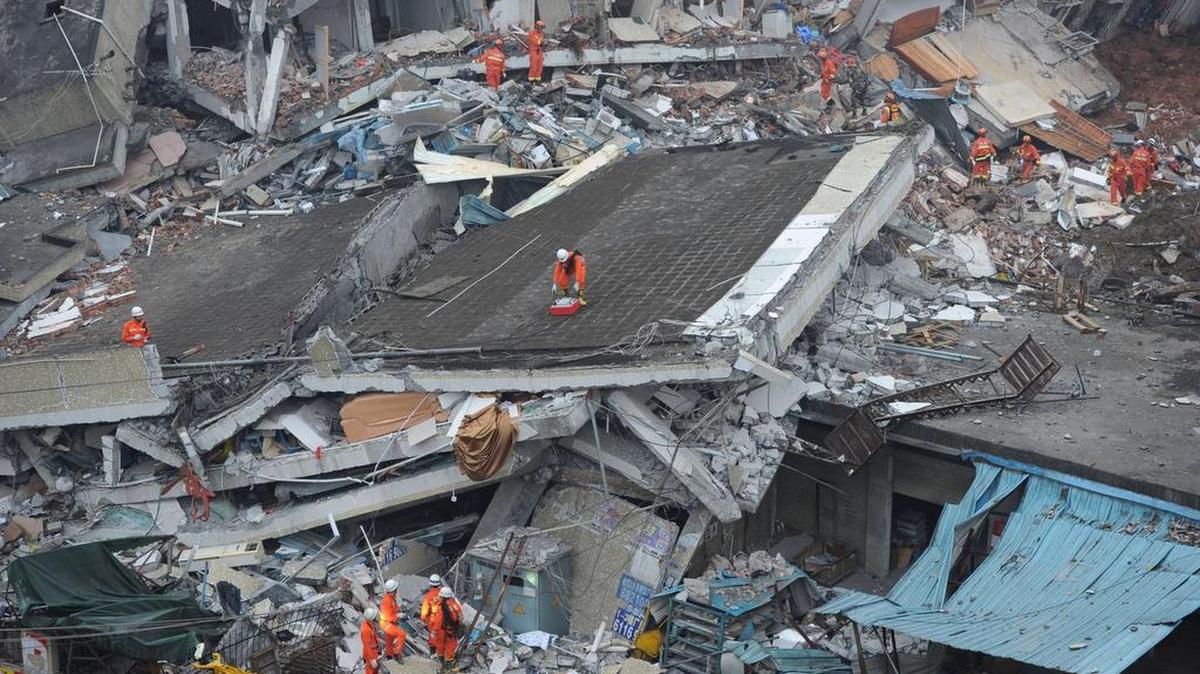 Rescatistas buscan sobrevivientes entre los escombros de numerosos edificios destruidos por un deslizamiento de tierra en Cantón, China, este domingo.