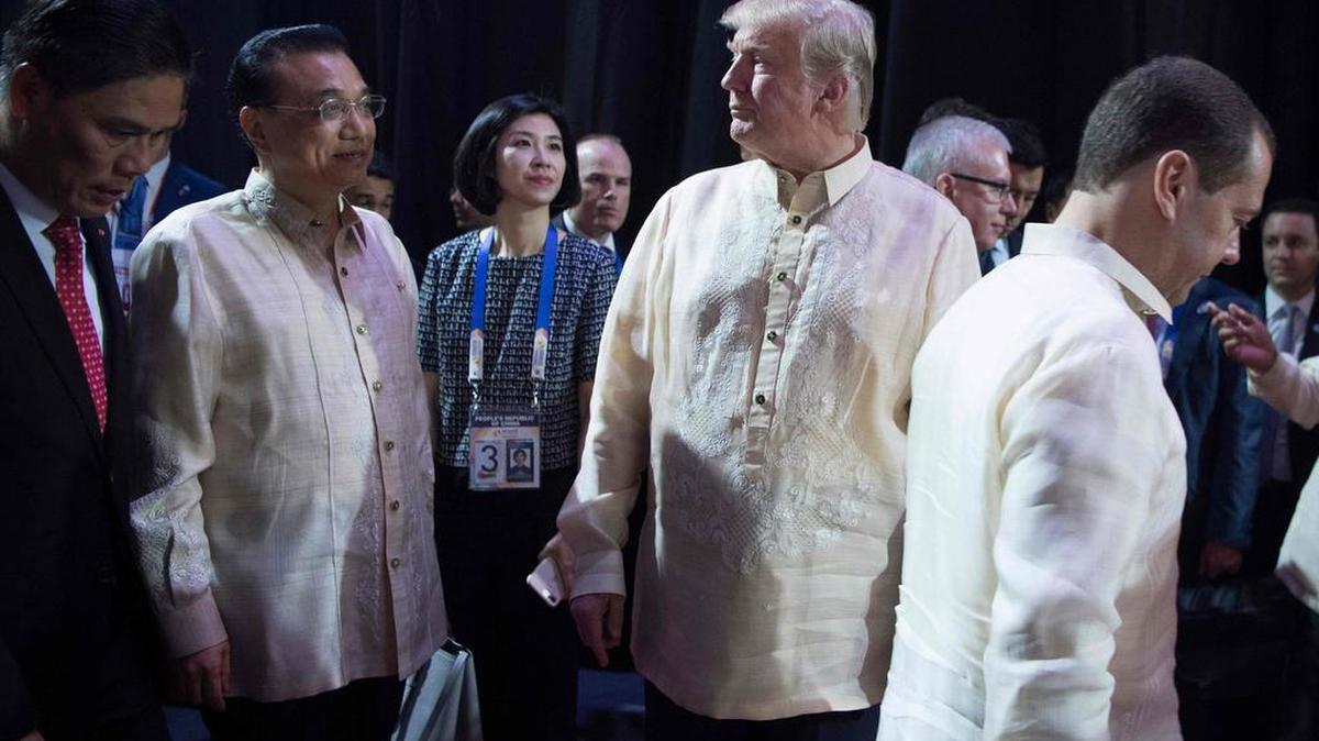 El primer ministro ruso Dmitry Medvedev (der.) pasa por el lugar donde está el presidente de EEUU, Donald Trump (cen.) y el primer ministro chino Li Keqiang (izq.) durante una cena de gala especial el 12 de noviembre de 2017.