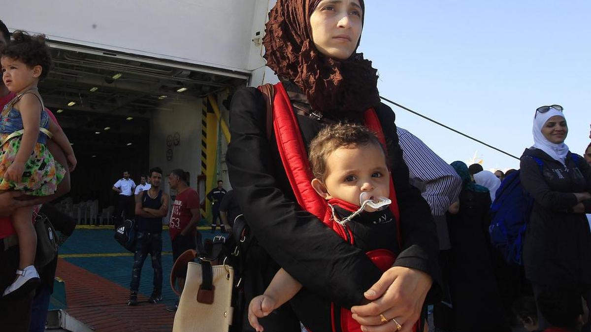 
Refugiados sirios bajan del ferri "Eleftherios Venizelos" a su llegada al puerto de Pireo (Grecia) el 20 de agosto de 2015. 
