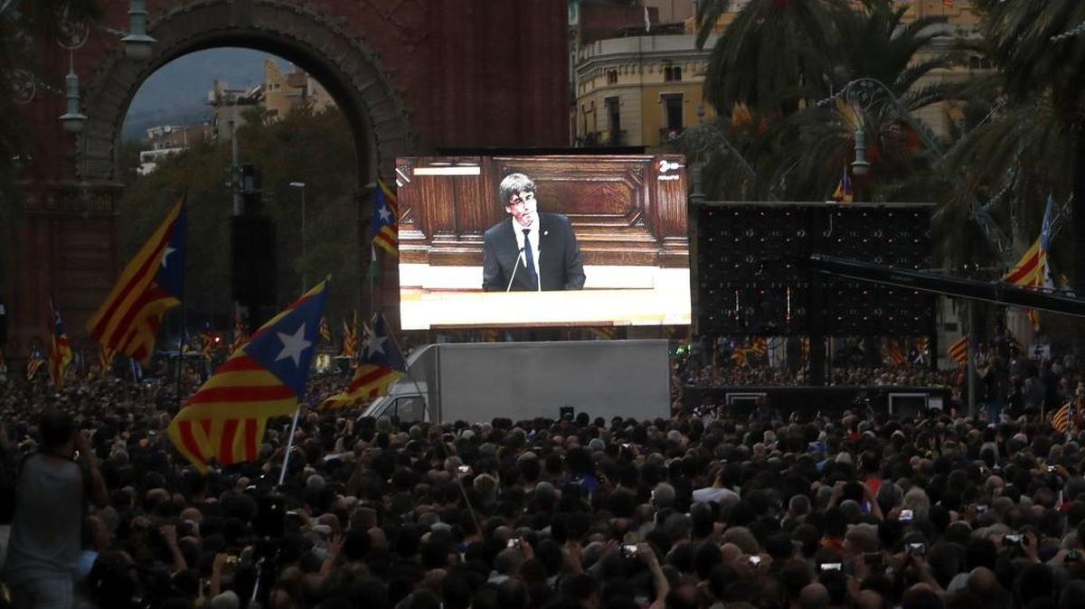 Vista de la concentración convocada esta tarde en las inmediaciones del Parlamento de Cataluña, para seguir a través de una gran pantalla la comparecencia del presidente de la Generalitat, Carles Puigdemont, en la que ha afirmado que asume el "mandato del pueblo" para que "Cataluña se convierta en un estado independiente en forma de república", pero seguidamente ha propuesto "suspender los efectos de la declaración de independencia" para abrir la puerta al diálogo.