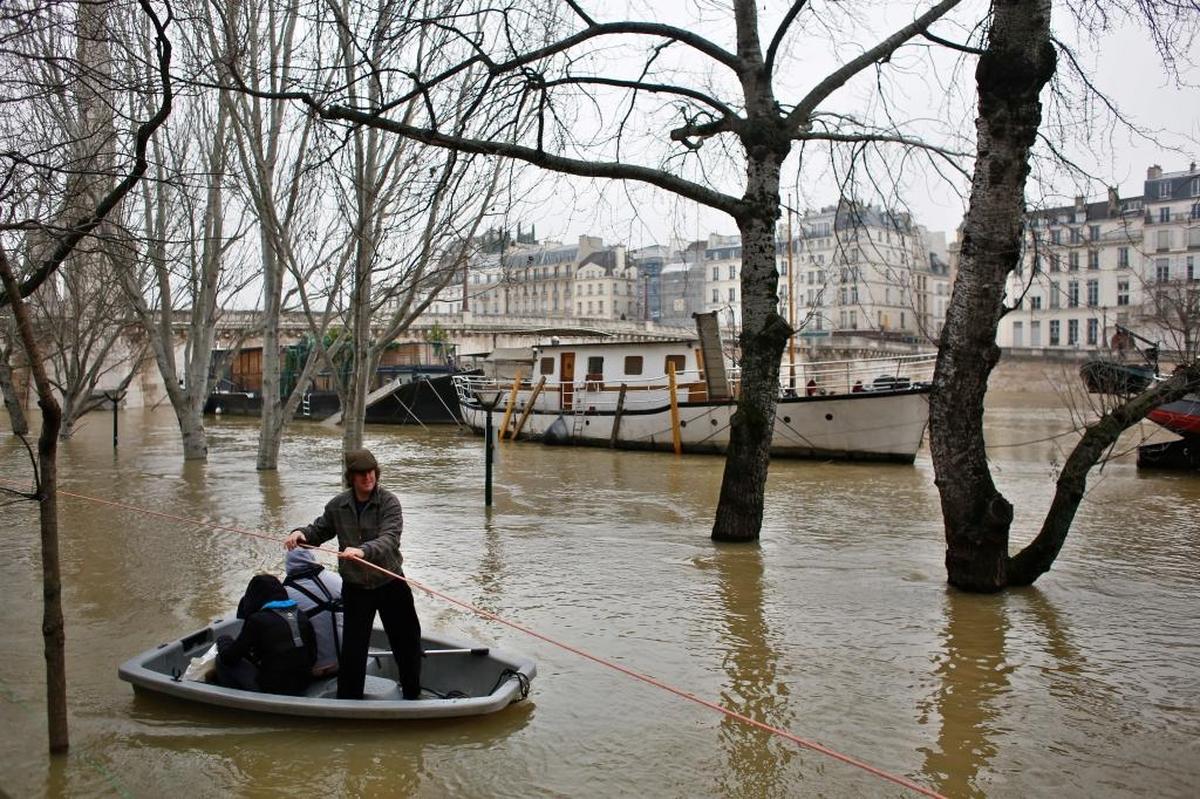 Muchas personas recurrieron a botes inflables para llegar a la orilla del Sena en París. El sábado las inundaciones obligaron a cerrar bodegas y sotanos de museos.