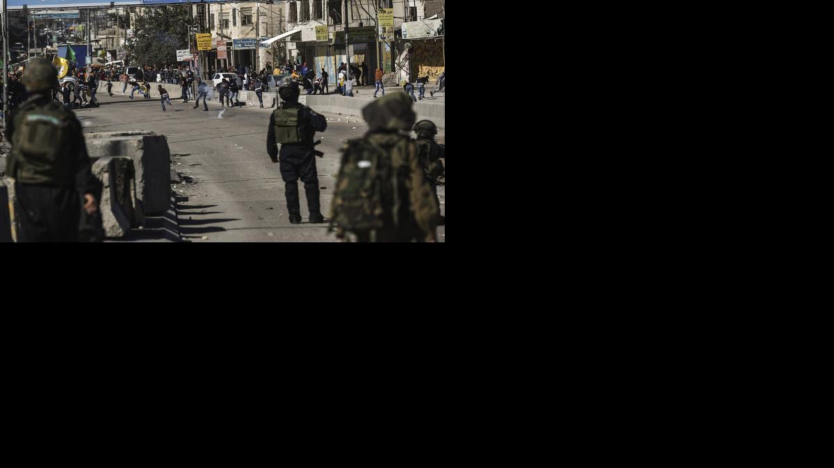 
Policias israelies toman posiciones durante enfrentamientos con manifestantes palestinos cerca del puesto de control de Kalandia, Cisjordania, este viernes.


