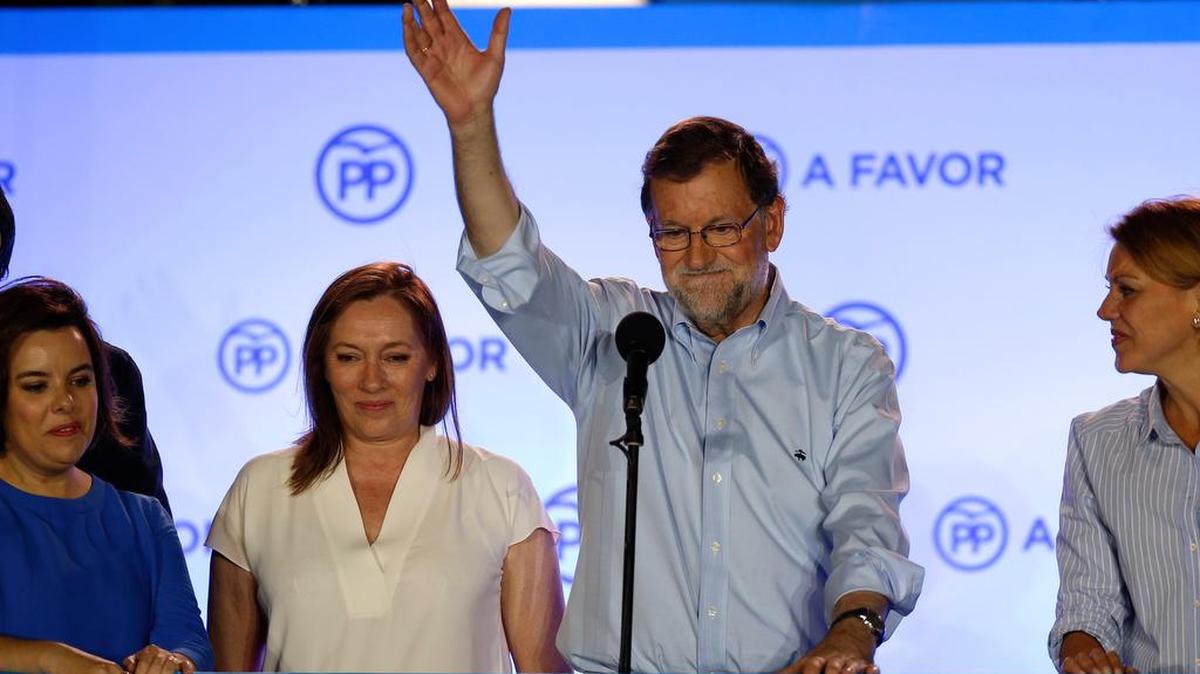 El presidente del gobierno español Mariano Rajoy saluda a sus partidarios, luego de conocer los resultados de las elecciones del domingo.