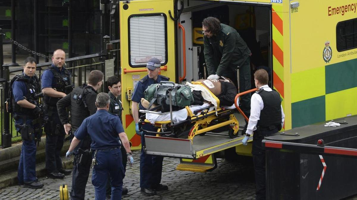 Un hombre es tratado por los servicios de emergencia afuera de las Cámaras del Parlamento en Londres, el miércoles 22 de marzo de 2017.