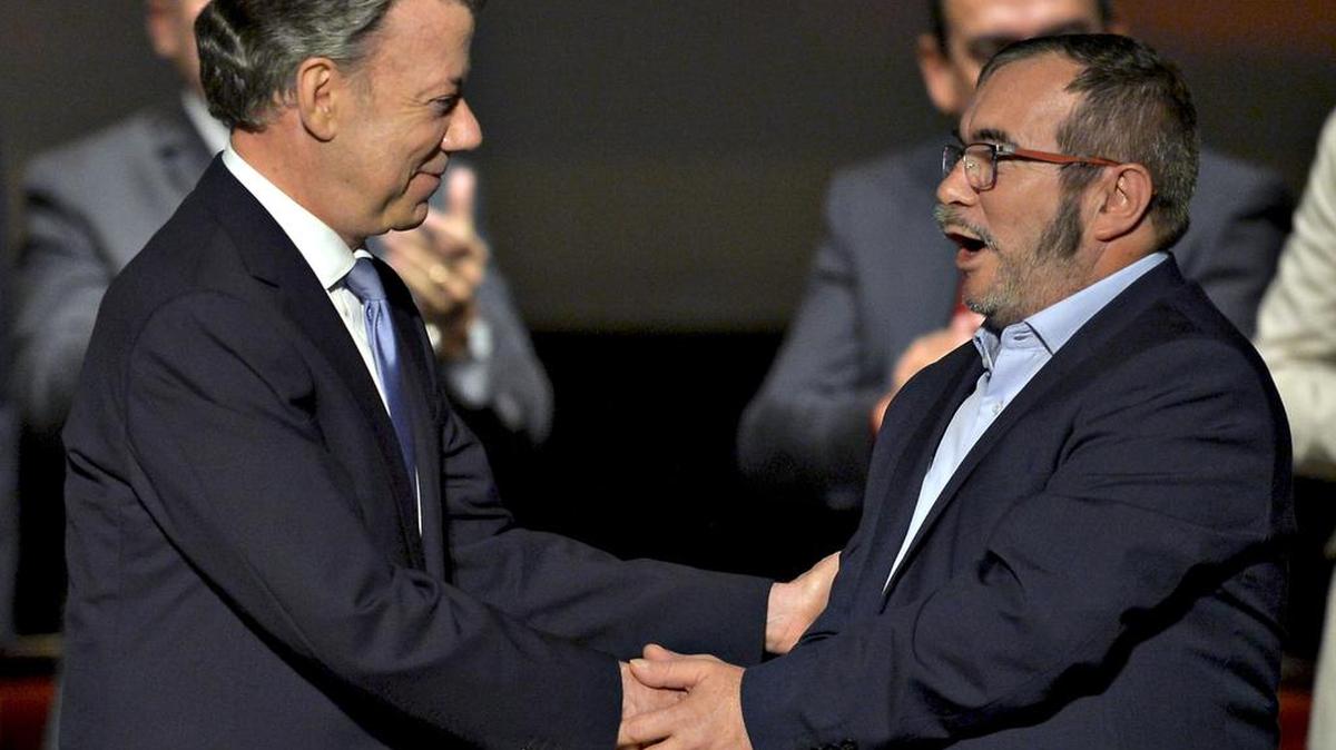 El presidente colombiano, Juan Manuel Santos, y el líder de las FARC, Timoleón Jiménez, también se estrechan las manos durante la segunda firma del acuerdo de paz entre el gobierno colombiano y las FARC, en el Teatro Colón de Bogotá, Colombia, el 24 de noviembre de 2016.