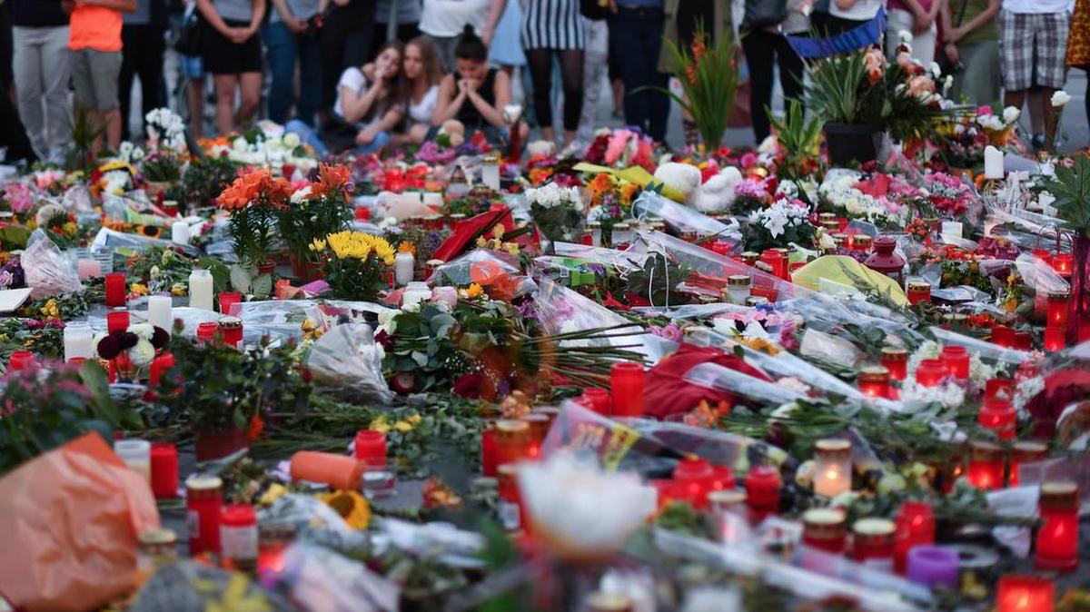 Numerosas personas rinden homenaje a las víctimas del centro comercial Olympia, en Munich, donde murieron 10 personas en un tiroteo, en una imagen del 24 de julio del 2016.