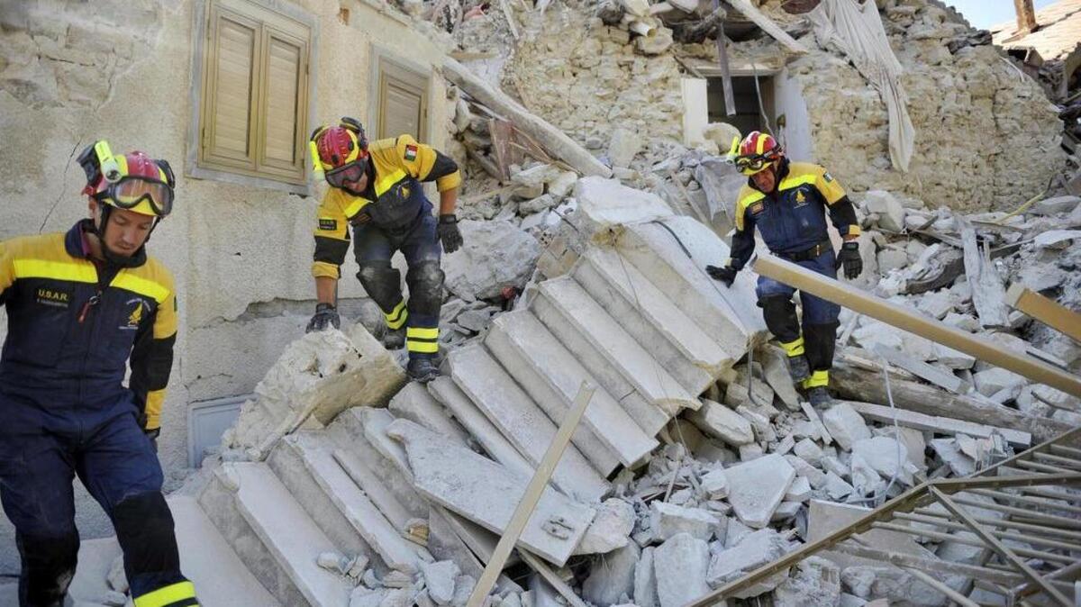 Varios bomberos trabajan entre los escombros en Pescara del Tronto, en la región de Marche, en el centro de Italia, hoy, 26 de agosto de 2016.