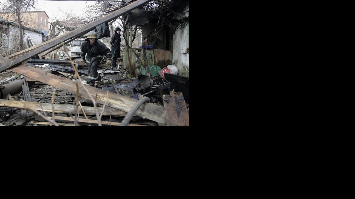 
Un bombero inspecciona los restos de una vivienda, en presencia de su dueña (d), tras un bombardeo el martes en Donetsk, Ucrania.



