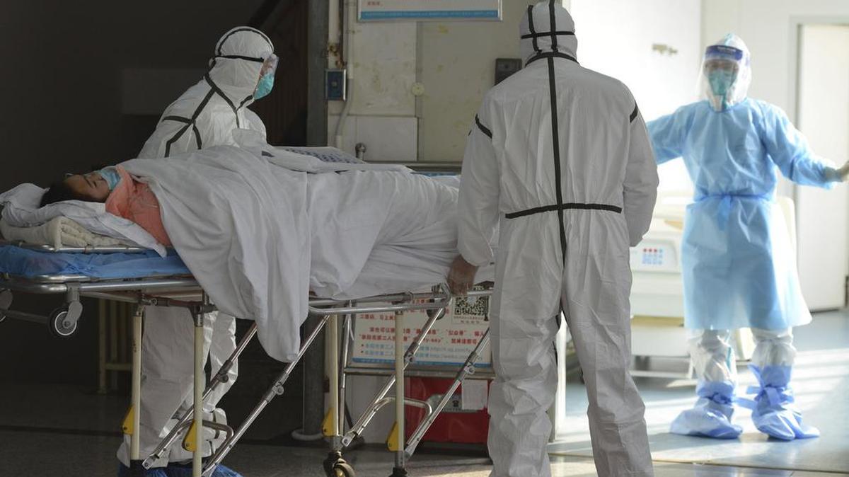 Personal médico traslada el sábado a un paciente con coronavirus a una sala de aislamiento en el Segundo Hospital del Pueblo en Fuyang, provincia china de Anhui.