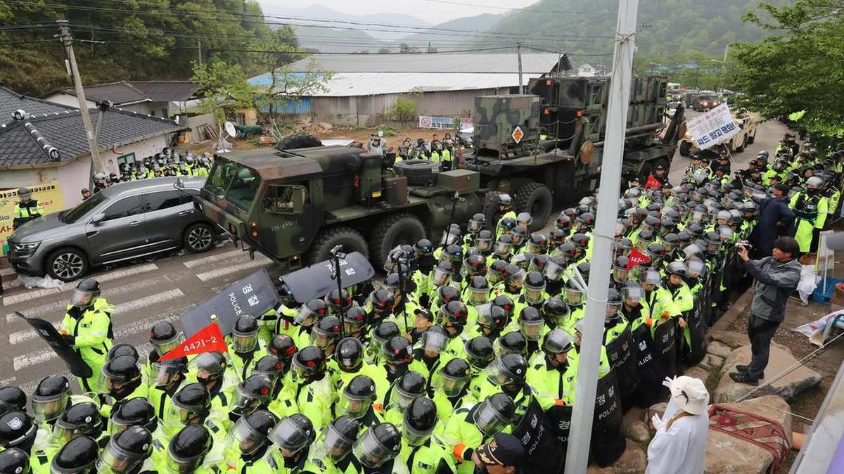 Los manifestantes y la policía aguardan que los remolques que llevan el equipo de defensa antimisiles estadounidense THAAD entren en un sitio de despliegue en Seongju, el 26 de abril de 2017.