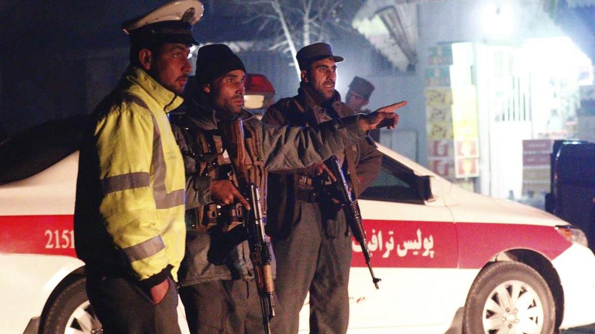 Miembros de los servicios de seguridad afganos permanecen en guardia en el lugar donde se ha producido un ataque talibán en Kabul, este viernes.
