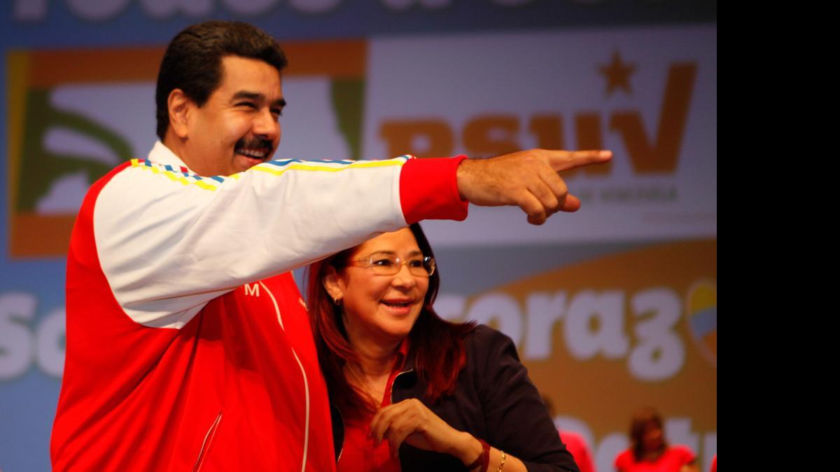 
Fotografía cedida por el Palacio de Miraflores que muestra al presidente venezolano, Nicolás Maduro (i), y a la primera dama, Cilia Flores (d), durante un acto del Partido Socialista Unido de Venezuela (PSUV), en Caracas (Venezuela). Maduro aseguró que, de ganar la oposición las elecciones parlamentarias del 6 de diciembre, sus diputados acabarían con las ayudas sociales conocidas como misiones, un "saboteo" contra el que el pueblo, dijo, "lucharía en las calles". "Nuestro pueblo no se va a entregar, nuestro pueblo va a luchar en las calles, sea la que sea la circunstancia que nos toque enfrentar. Así lo digo, así lo asumo. Sería el primero en lanzarme en las calles con el pueblo a defender sus derechos sociales", aseguró Maduro.
