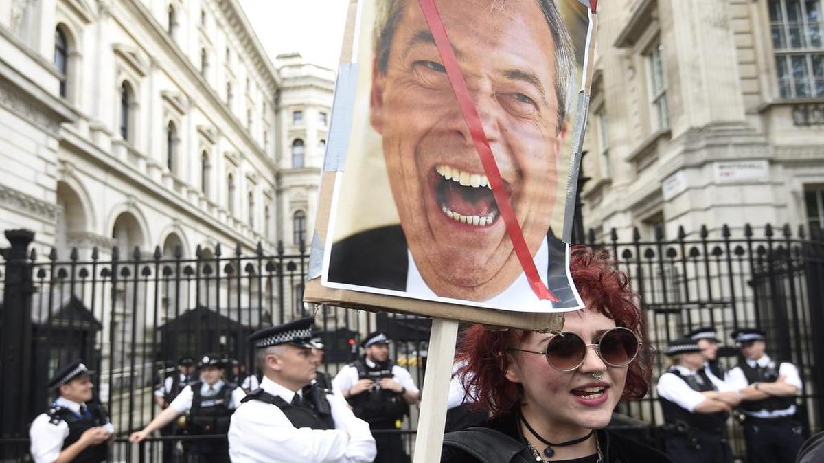 Una manifestante que apoyaba la permanencia del Reino Unido en la Unión Europea protesta el 24 de junio frente a la residencia del ex primer ministro británico, David Cameron, en la calle número 10 de Downing Street en Londres. El hombre en la pancarta es el ministro británico encargado del “brexit”, David Davis. 