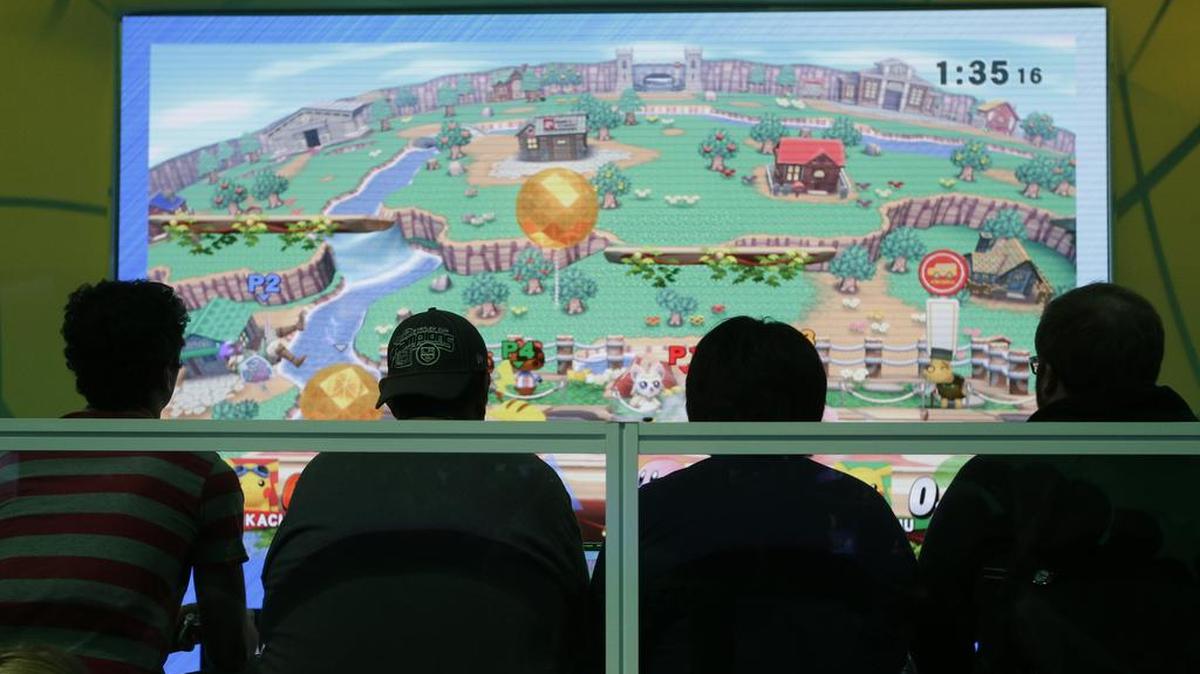 Varias personas participan en un juego de Nintendo en una exhibición en Los Angeles.