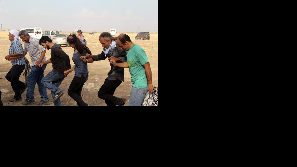 
Activistas kurdos de Turquía bailan cerca de la frontera siria, donde acampan para impedir el paso de yihadistas y armas al Estado Islámico. 
