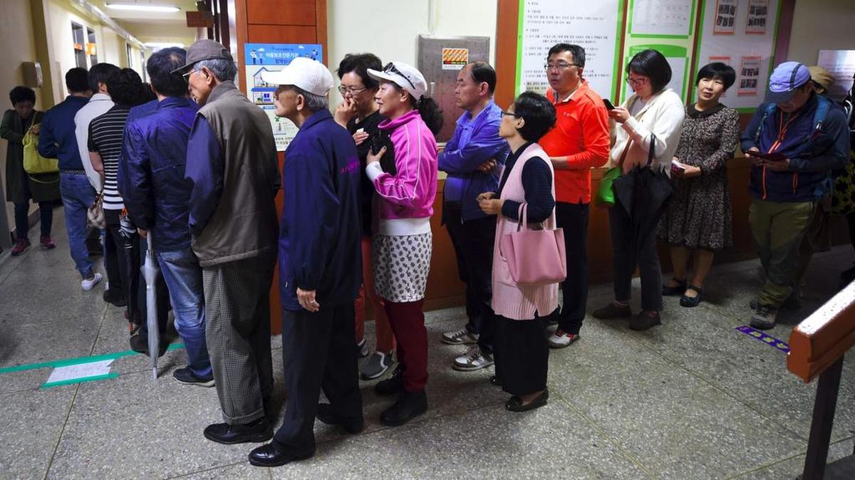 Surcoreanos esperan en fila para votar en la elección presidencial, en una mesa de votación en Seúl el 9 de mayo de 2017.