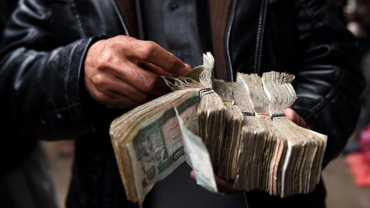 En esta fotografía tomada el 28 de febrero de 2017, los cambistas afganos cuentan billetes en el patio del mercado cambiario Sarayee Shahzada en Kabul. Los secuestros y la extorsión se han convertido en una industria casera, mientras que los robos de coches son comunes. De hecho, Kabul, es una ciudad tan llena de delitos que mostrar la riqueza puede ser equivalente a una sentencia de muerte.