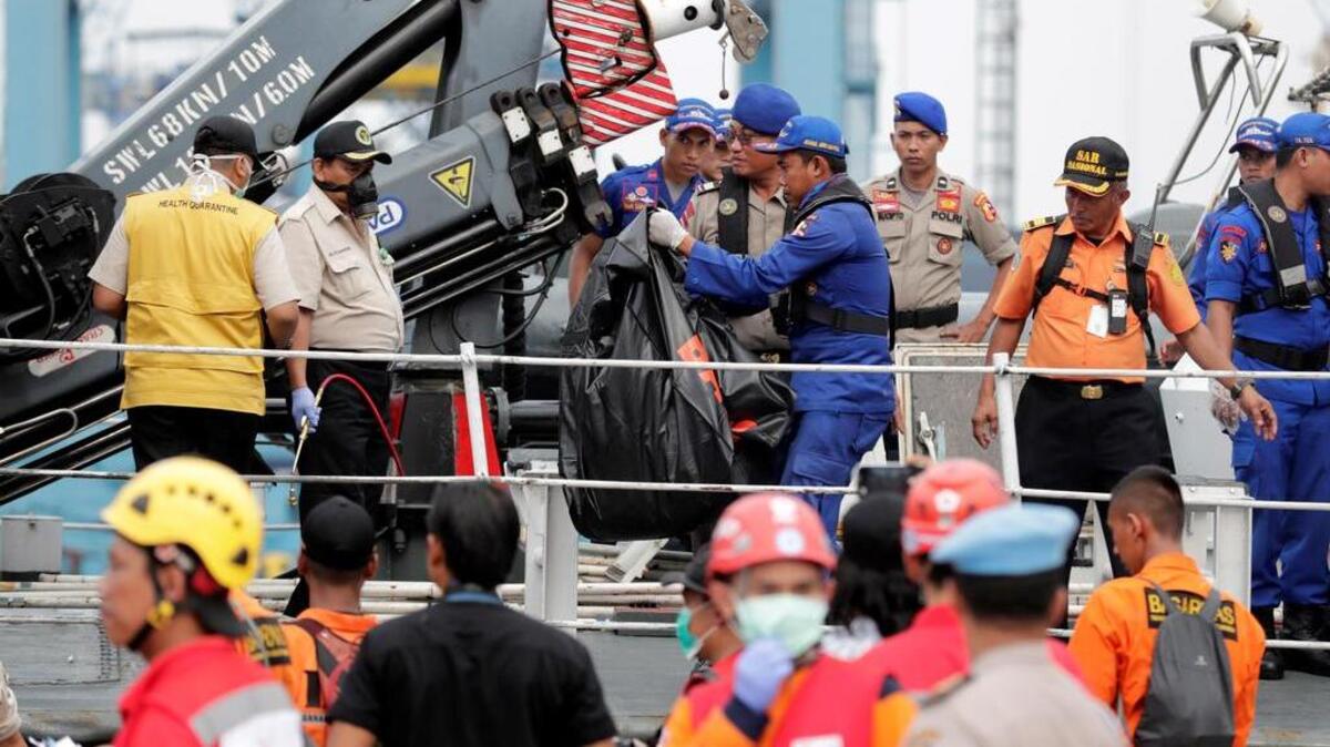 Miembros de los servicios de rescate recuperan el cuerpo sin vida de una de las víctimas de un avión accidentado en el puerto Tanjung Priok durante las tareas de rescate en el mar de Java cerca de la costa indonesia hoy, 30 de octubre de 2018.
