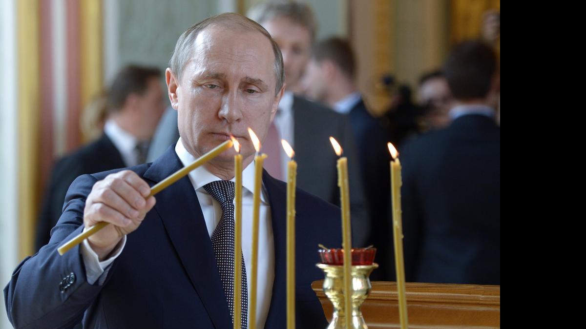 
El presidente ruso Vladimir Putin enciende un candelabro durante un servicio religioso en Moscú.


