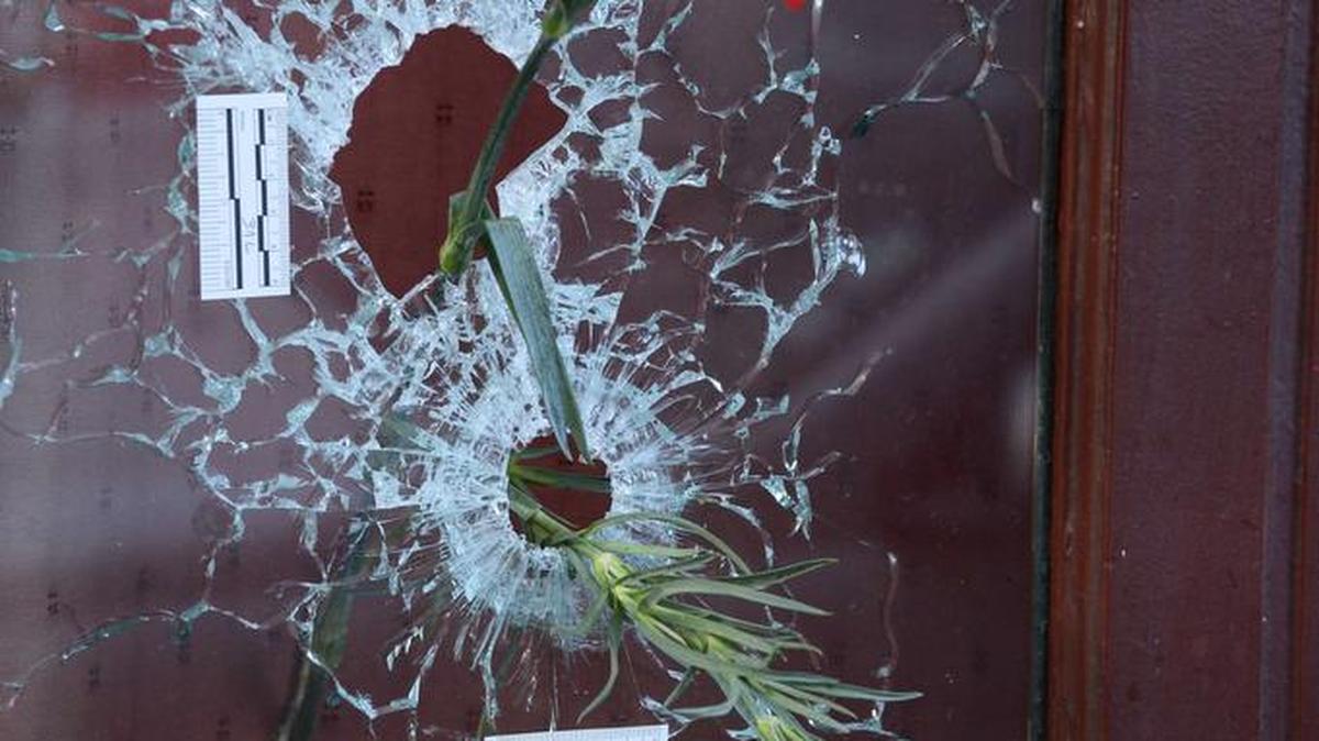 Esta foto tomada el 15 de noviembre 2015 muestra flores colocadas en los agujeros de bala en un sitio conmemorativo fuera de la barra de Carillon, en el distrito 10 de París. Jihadistas islámicos estatales demandaron una serie de ataques coordinados por hombres armados y terroristas suicidas en París.