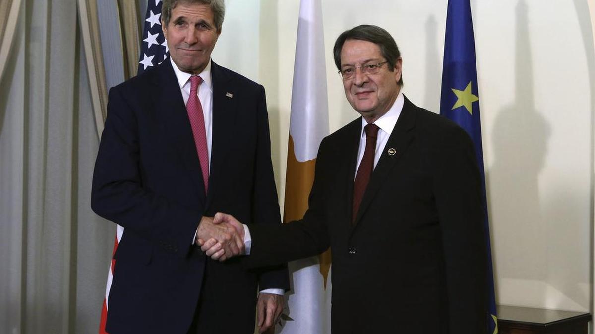 El presidente de Chipre, Nicos Anastasiades (der.), estrecha la mano del secretario de Estado de EEUU, John Kerry (izq.) en Nicosia, Chipre, el jueves.