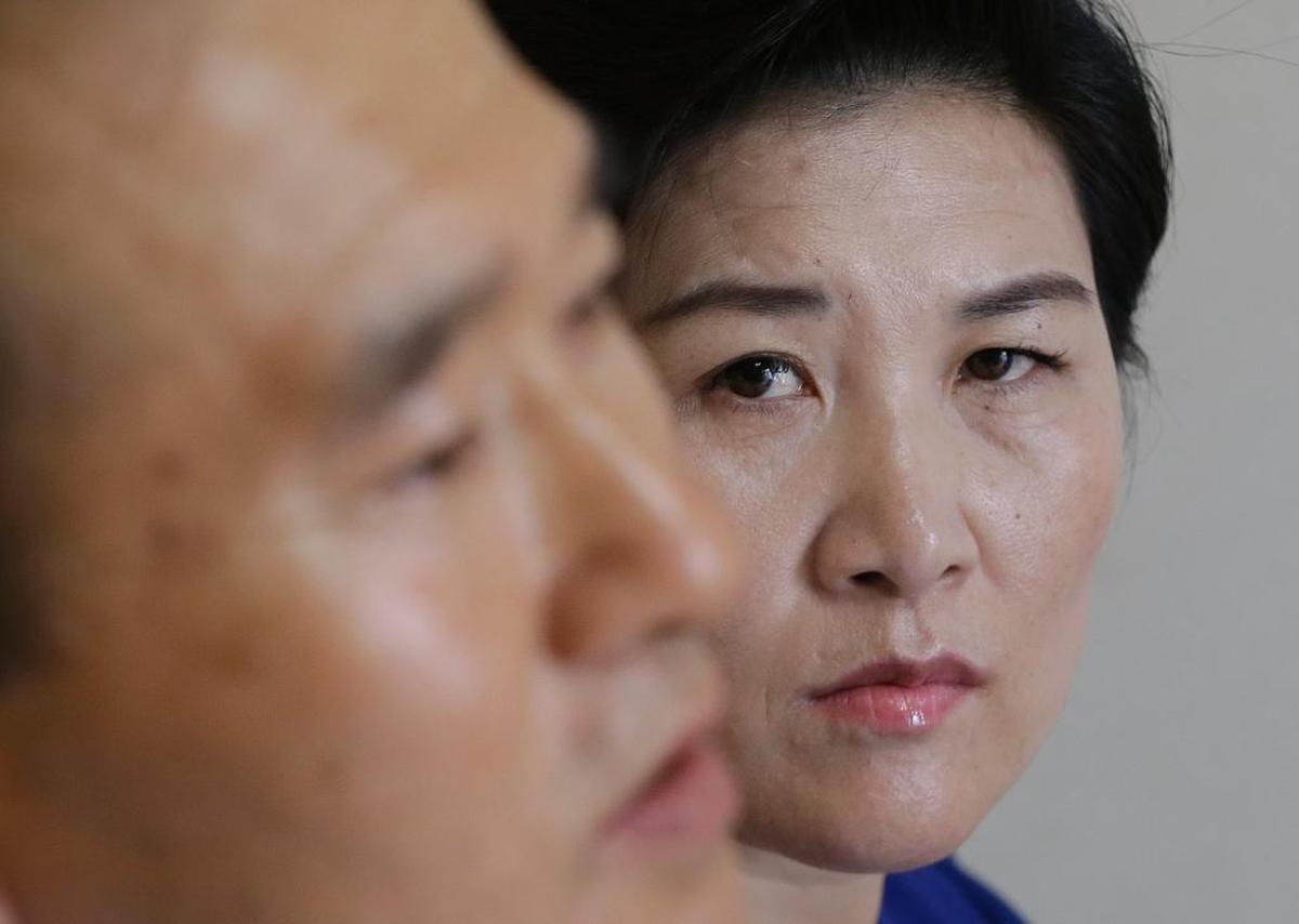 Kim Jungah, (dcha.), observa a su marido durante una entrevista en su casa en Corea del Sur.