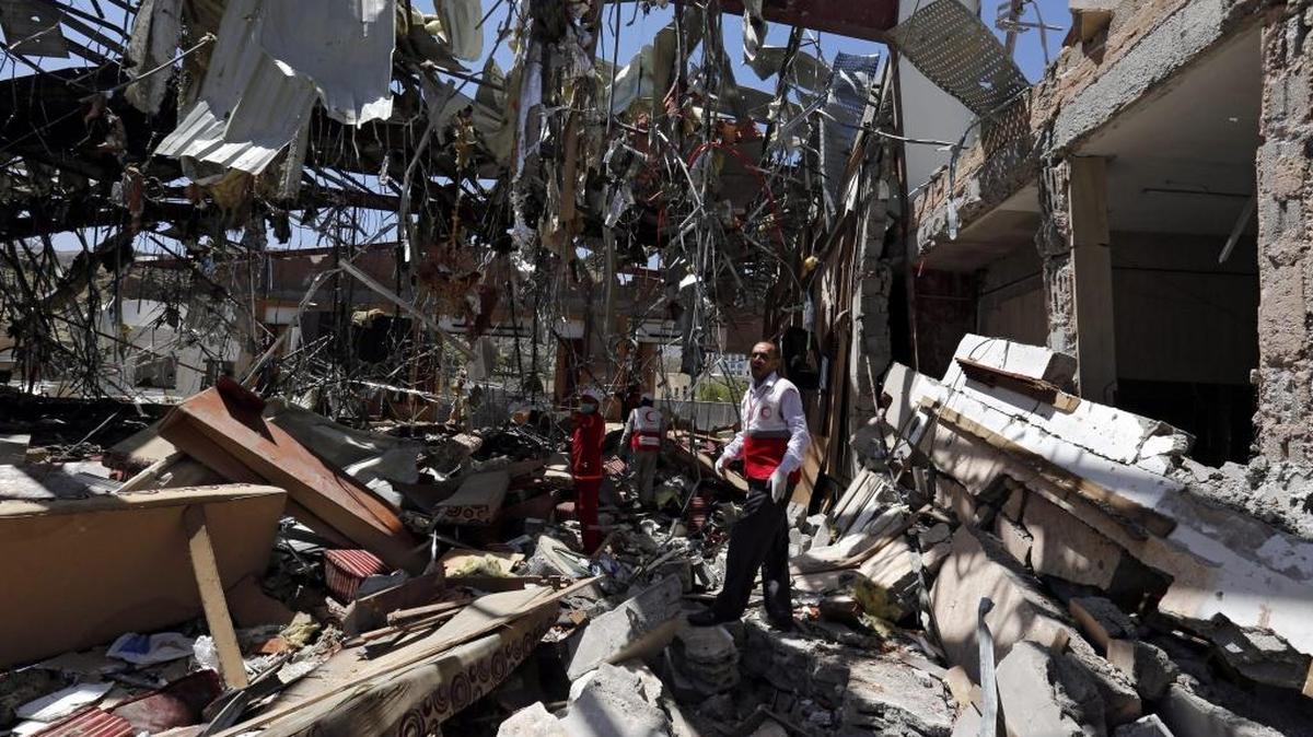 Miembros de la Media Luna Roja buscan víctimas entre los escombros del centro funerario que fue bombardeado por aviones de la coalición saudí el sábado.